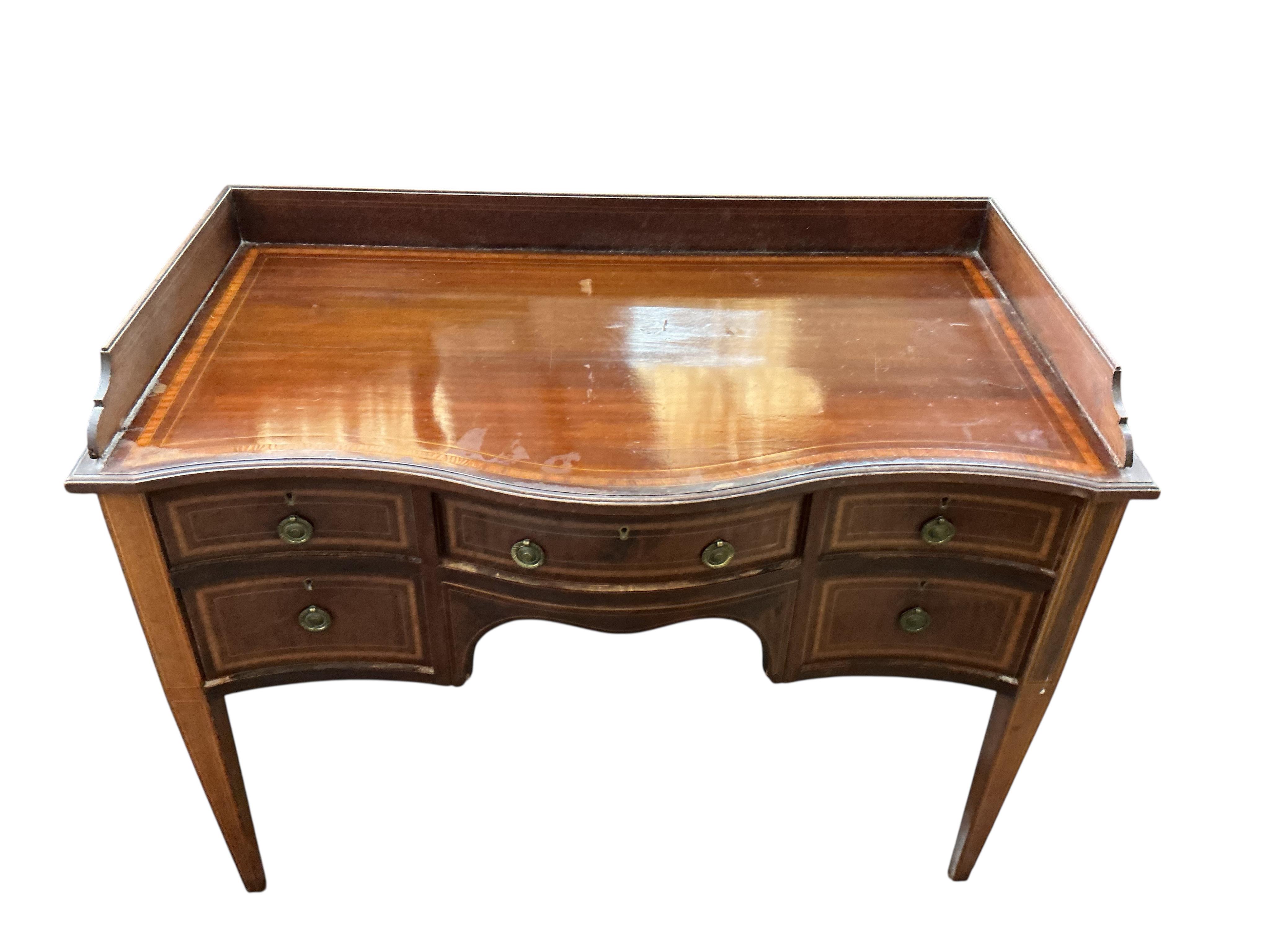An Edwardian satinwood banded serpentine mahogany dressing table, on tapered legs, width 106cm, depth 54cm, height 82cm